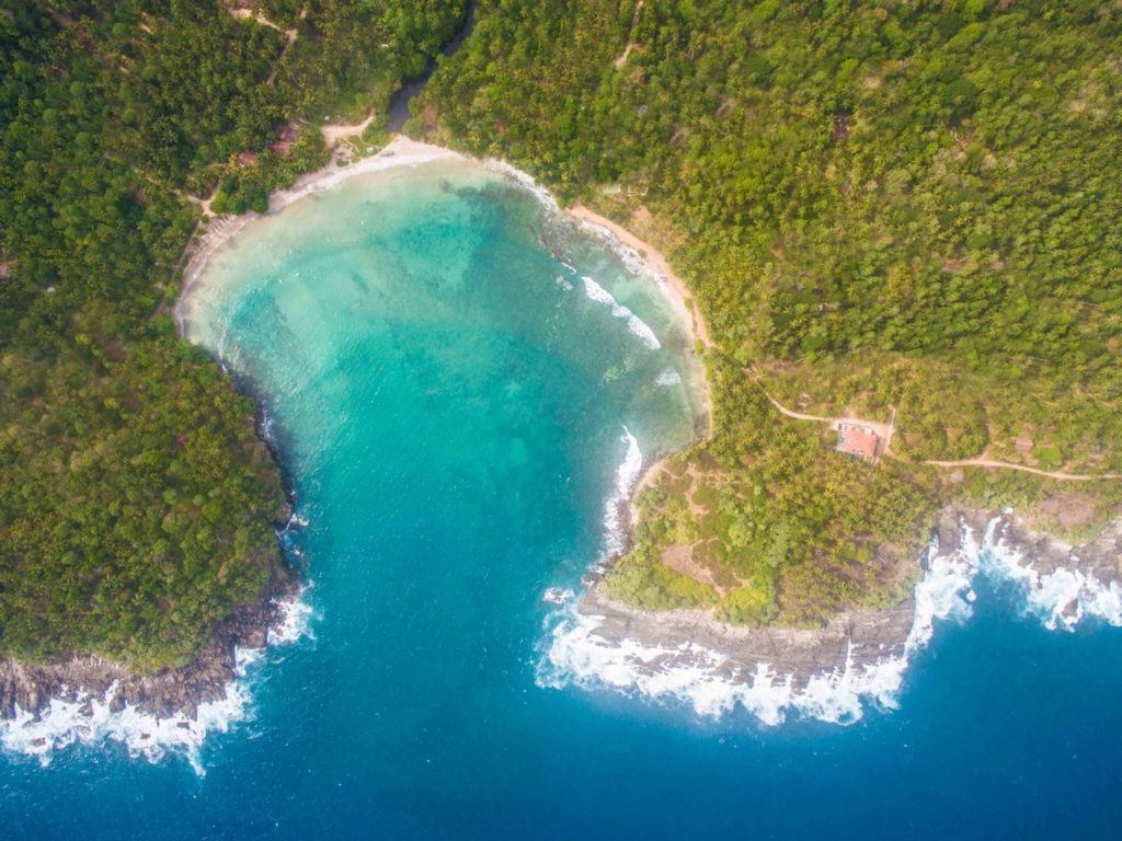 Aerial view of Hiriketiya bay horseshoe cove and jungle headland