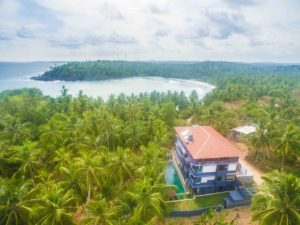 Aerial view of Jasper House surrounded by palm trees near Hiriketiya bay