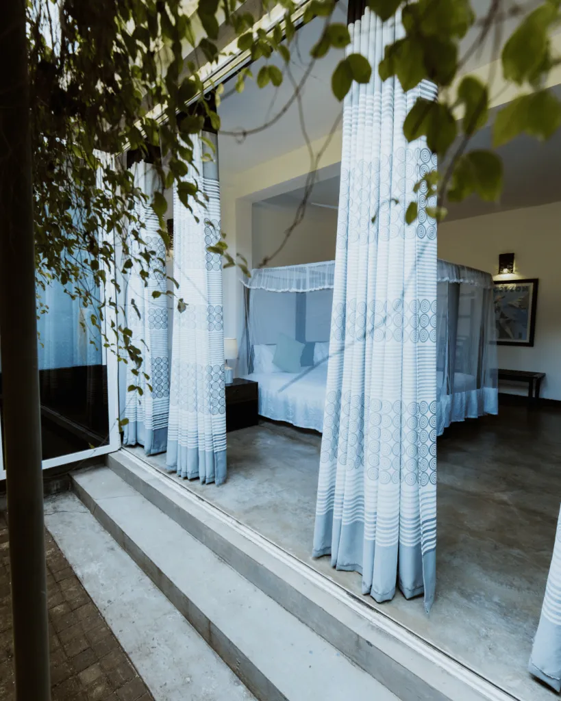 Sheer curtains opening to a canopy bedroom at Jasper House