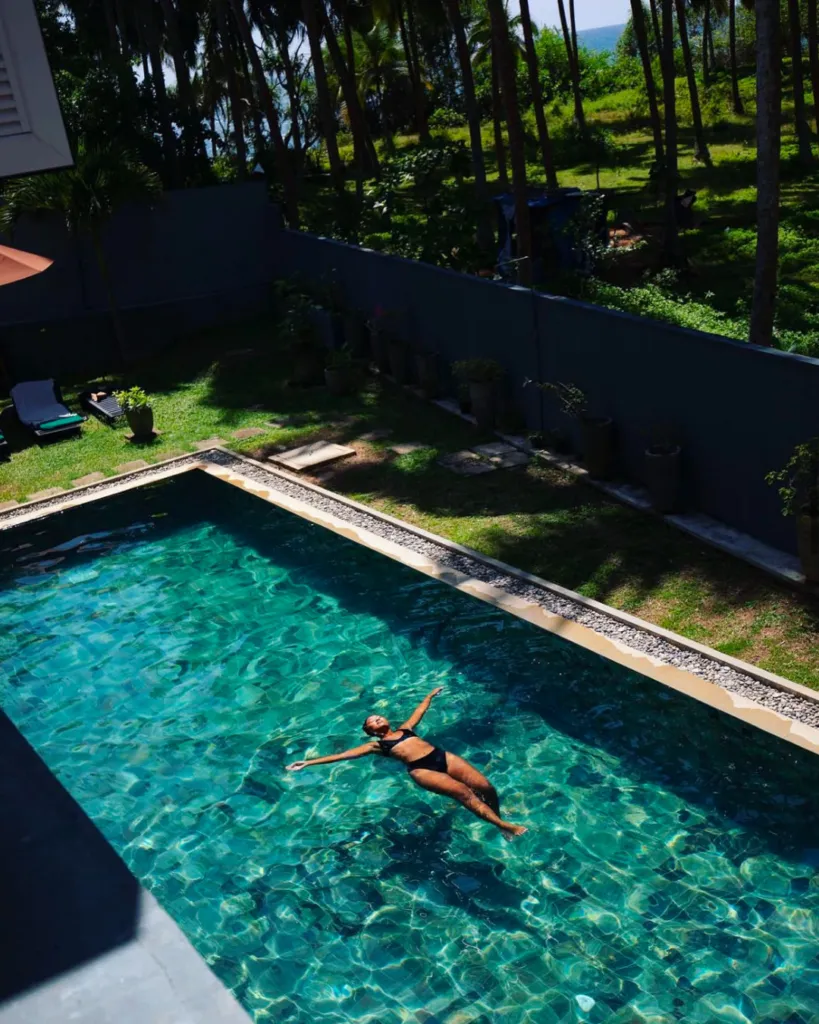 Guest swimming in the jungle-fringed pool at Jasper House Hiriketiya