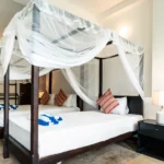Four-poster bed with fresh white linen in the Deluxe Family Room