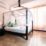 Light-filled Deluxe Standard Room with canopy bed and terrace doors