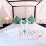 Towel swans and canopy detail on the Deluxe Standard Room bed