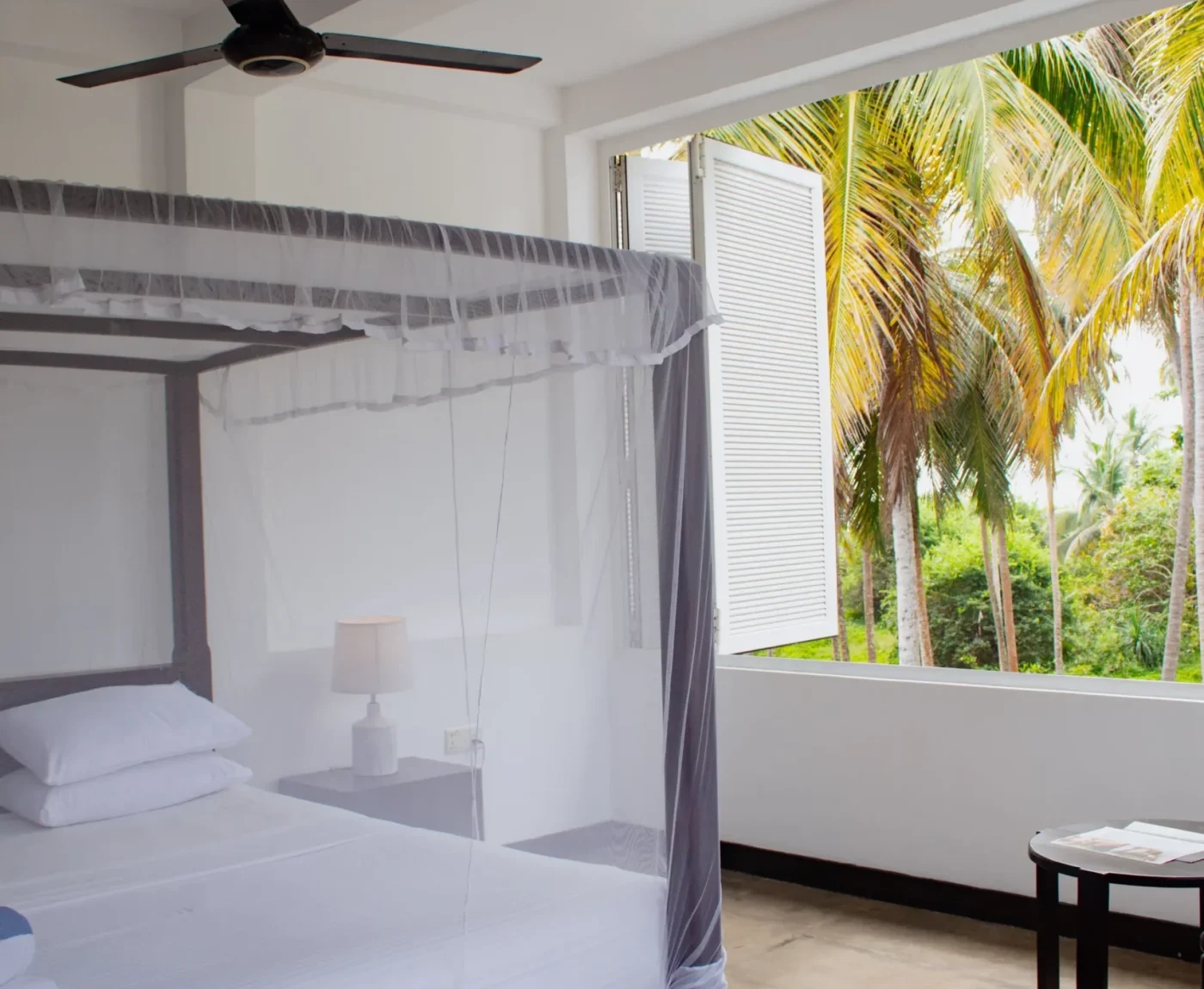 Deluxe Open Air Room with white bedding and palm tree outlook